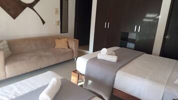 Una habitación de hotel con cama, sofá y armario.