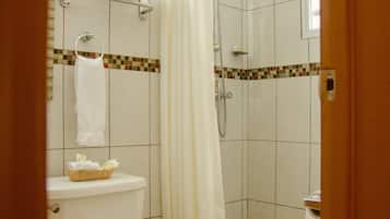 A bathroom with a toilet, a shower, and a towel rack.