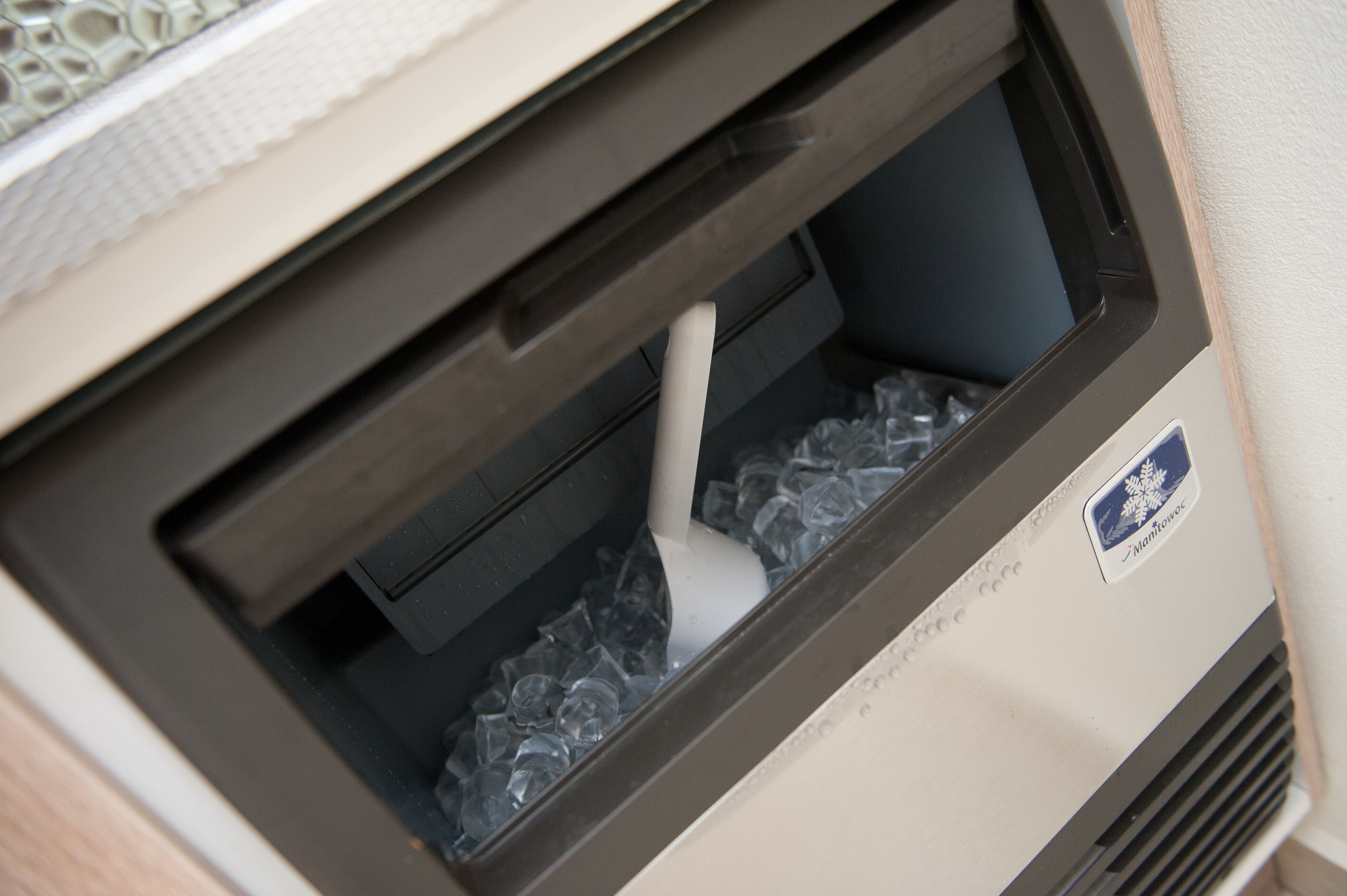 Un refrigerador con un compartimento congelador que contiene cubitos de hielo.