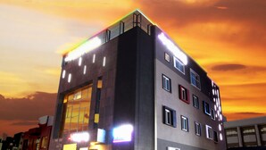 A multi-story building with a flat roof and a large glass facade on the ground floor. - Jeju Lux Hotel (Seogwipo)