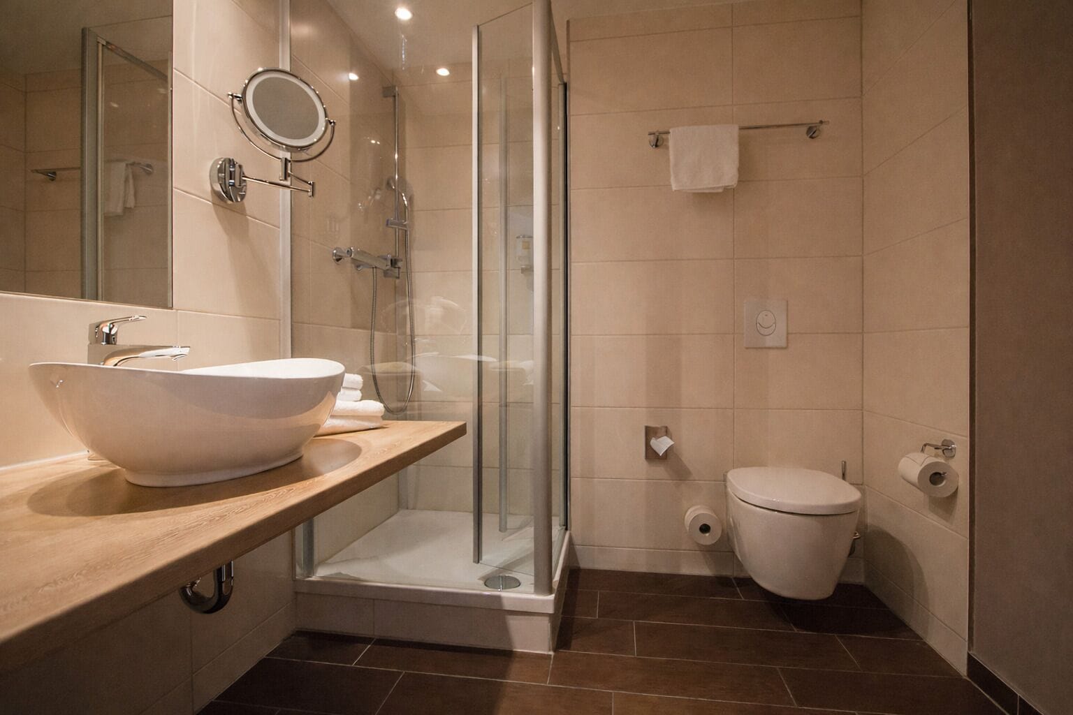 Une salle de bain moderne avec un grand lavabo sur pied, une douche à parois de verre et des toilettes.