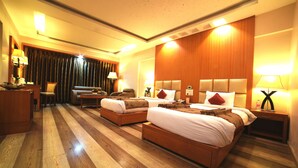 A hotel room with two beds, wooden flooring, and a large window with curtains. - Hotel Babylon Inn (Raipur)