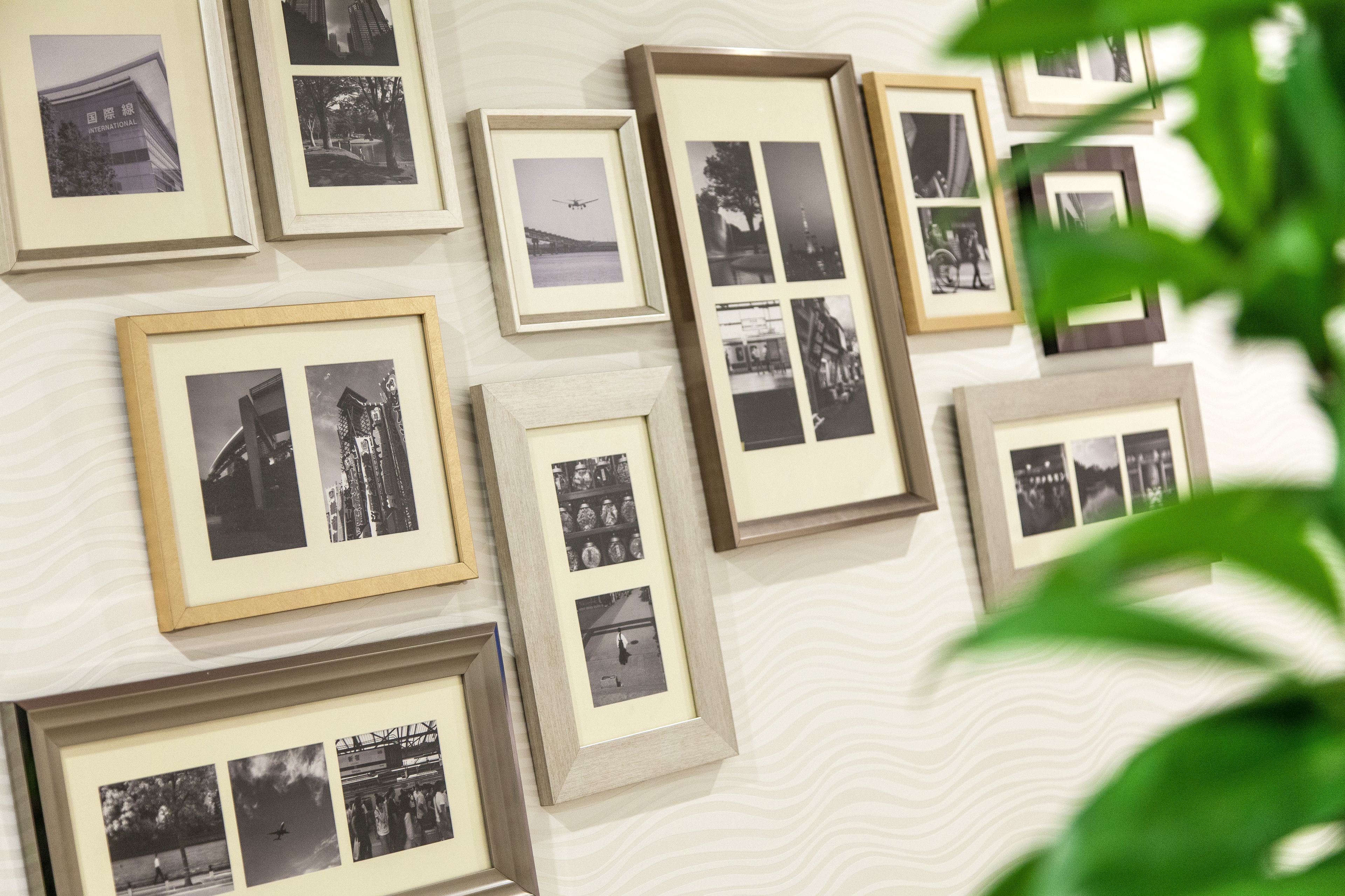 Una pared con múltiples fotografías enmarcadas de diferentes escenas y edificios.