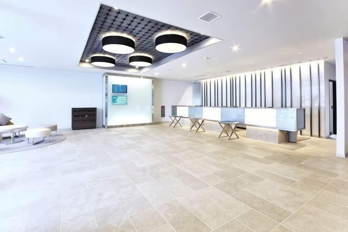 Um hall amplo com design moderno no teto, balcão de recepção e área de estar.
