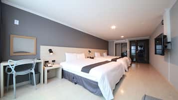Una habitación de hotel moderna con una cama grande, un escritorio, una silla y un televisor montado en la pared.