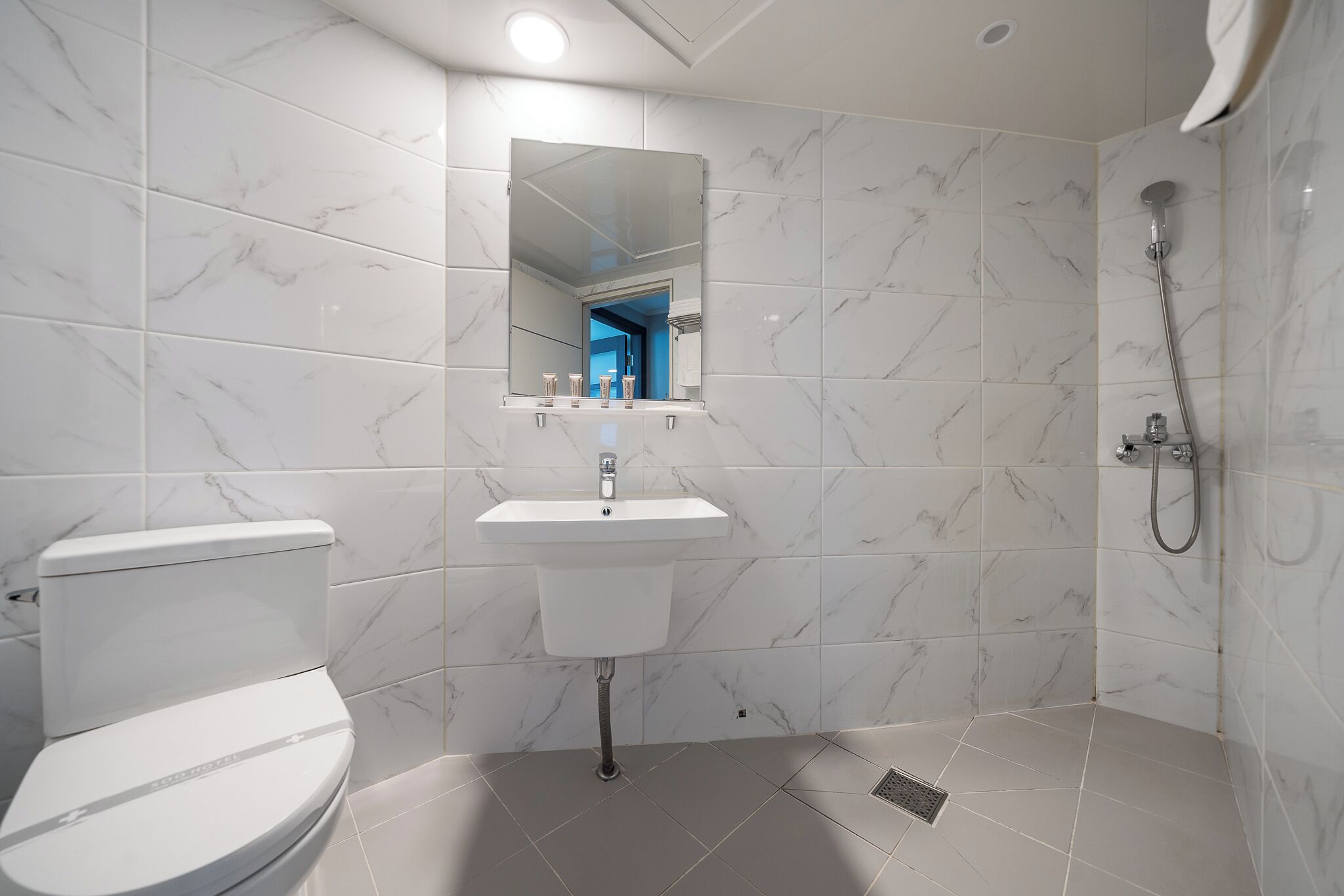 Un baño moderno con inodoro, lavamanos y ducha.