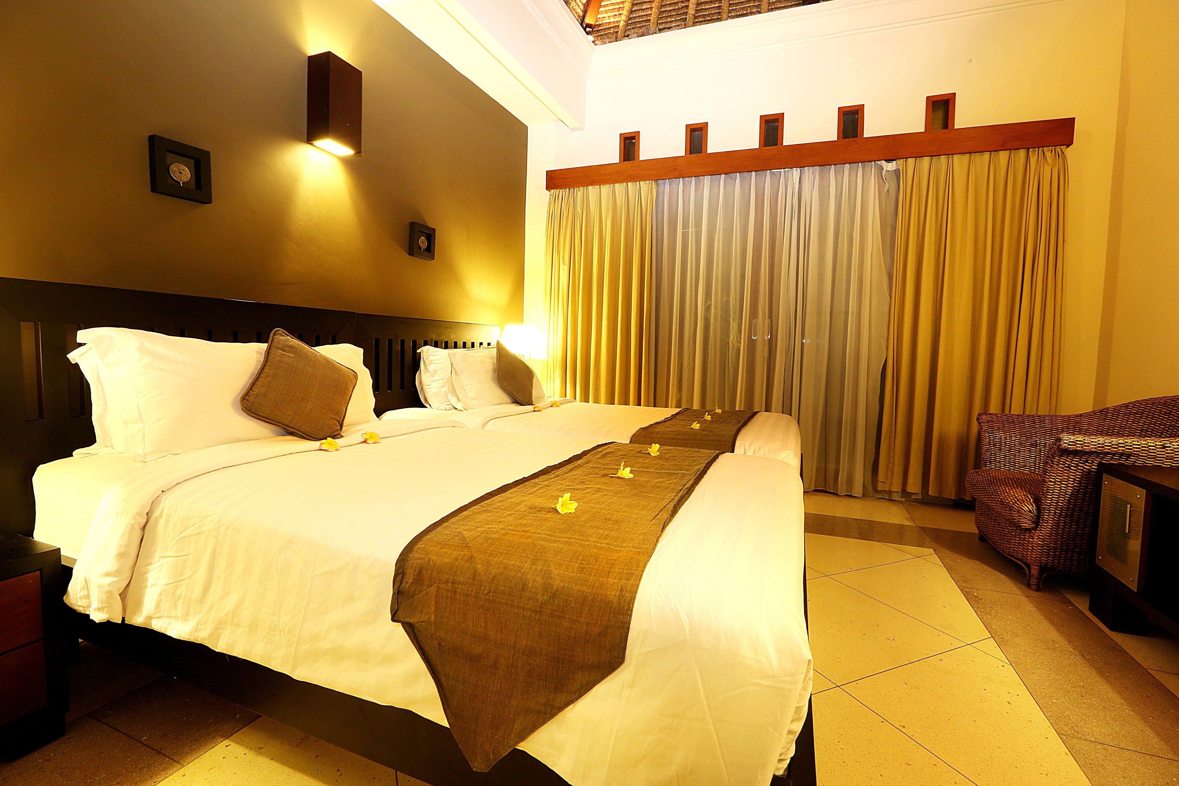 A hotel room with a large bed, a nightstand, a chair, and a desk.