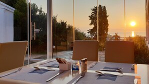 Een eettafel voor twee met uitzicht op de zonsondergang.