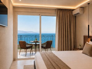 A hotel room with a bed, a balcony with a view of the sea, and two wicker chairs. - Hotel Yannis Corfu (Corfu)
