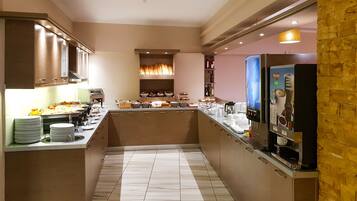 Una cuina moderna amb una illa central, equipada amb una màquina de cafè, i diversos aliments exposats a la barra.