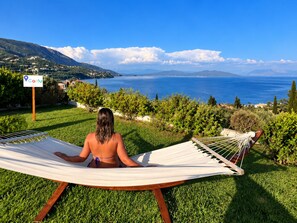 A hammock on grass with a view of the sea and mountains. - Hotel Yannis Corfu (Corfu)