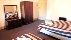 Ein Schlafzimmer mit Bett, Kleiderschrank und Spiegel.
