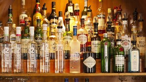 Eine Bar mit mehreren Regalen voller Spirituosenflaschen und Gläsern.