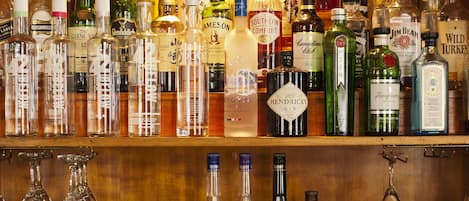 Un bar con varias estanterías llenas de botellas de licores y vasos.