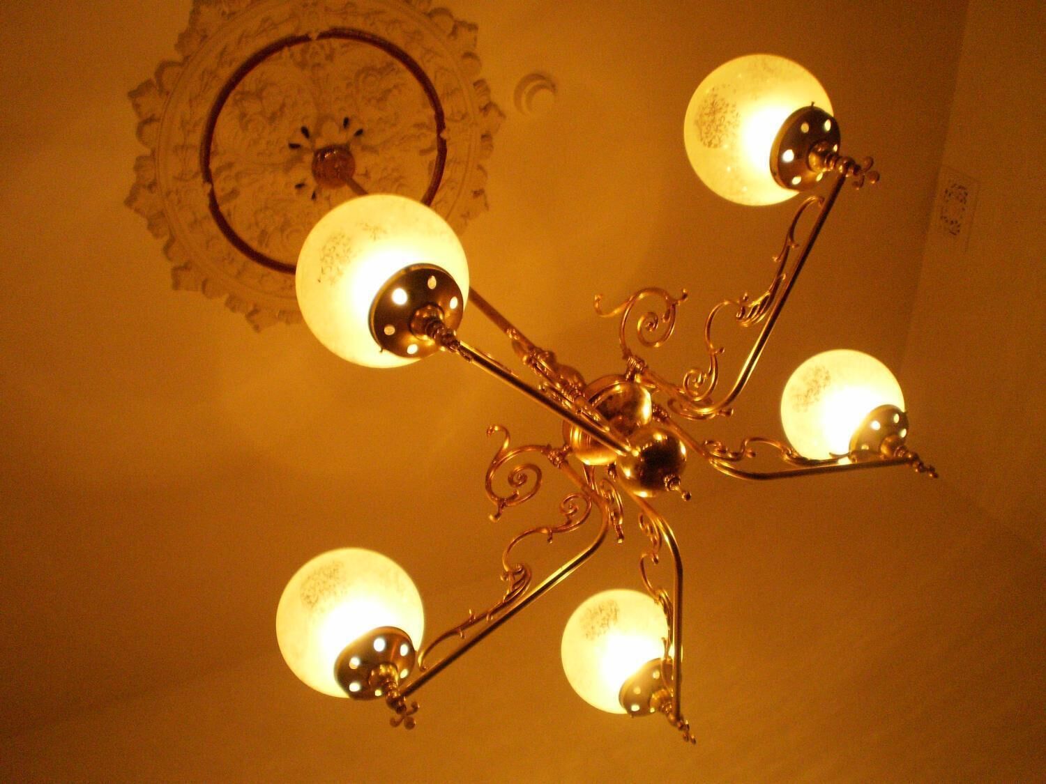 A chandelier with multiple spherical light fixtures and ornate metalwork.