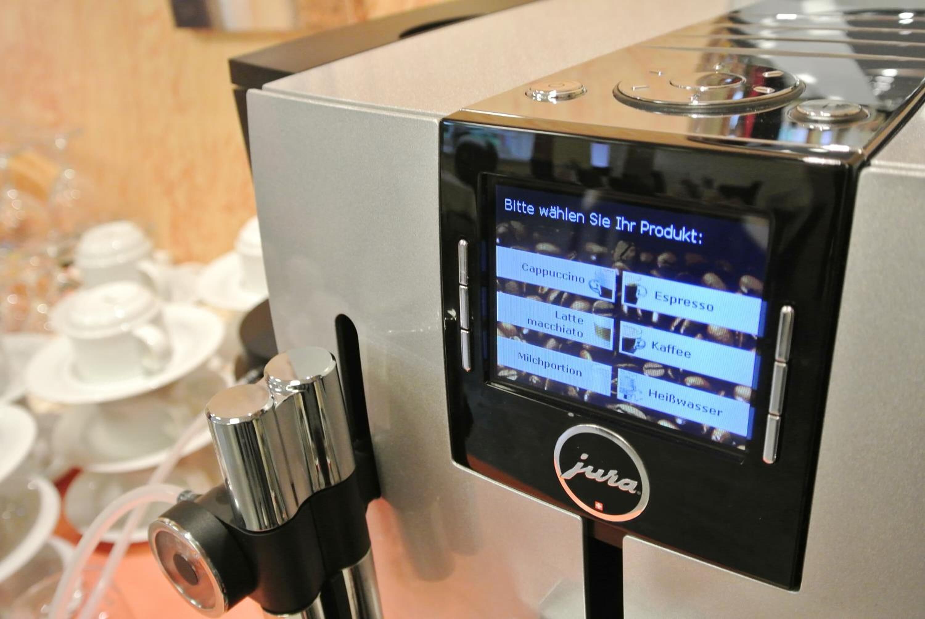 A coffee machine with a touchscreen interface displaying various drink options.