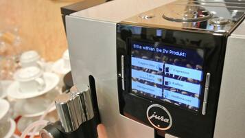 A coffee machine with a touchscreen interface displaying various drink options.