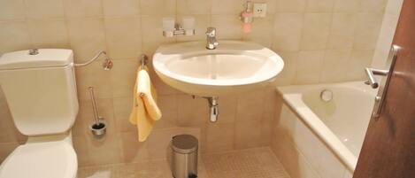 Un baño con inodoro, lavamanos y bañera.