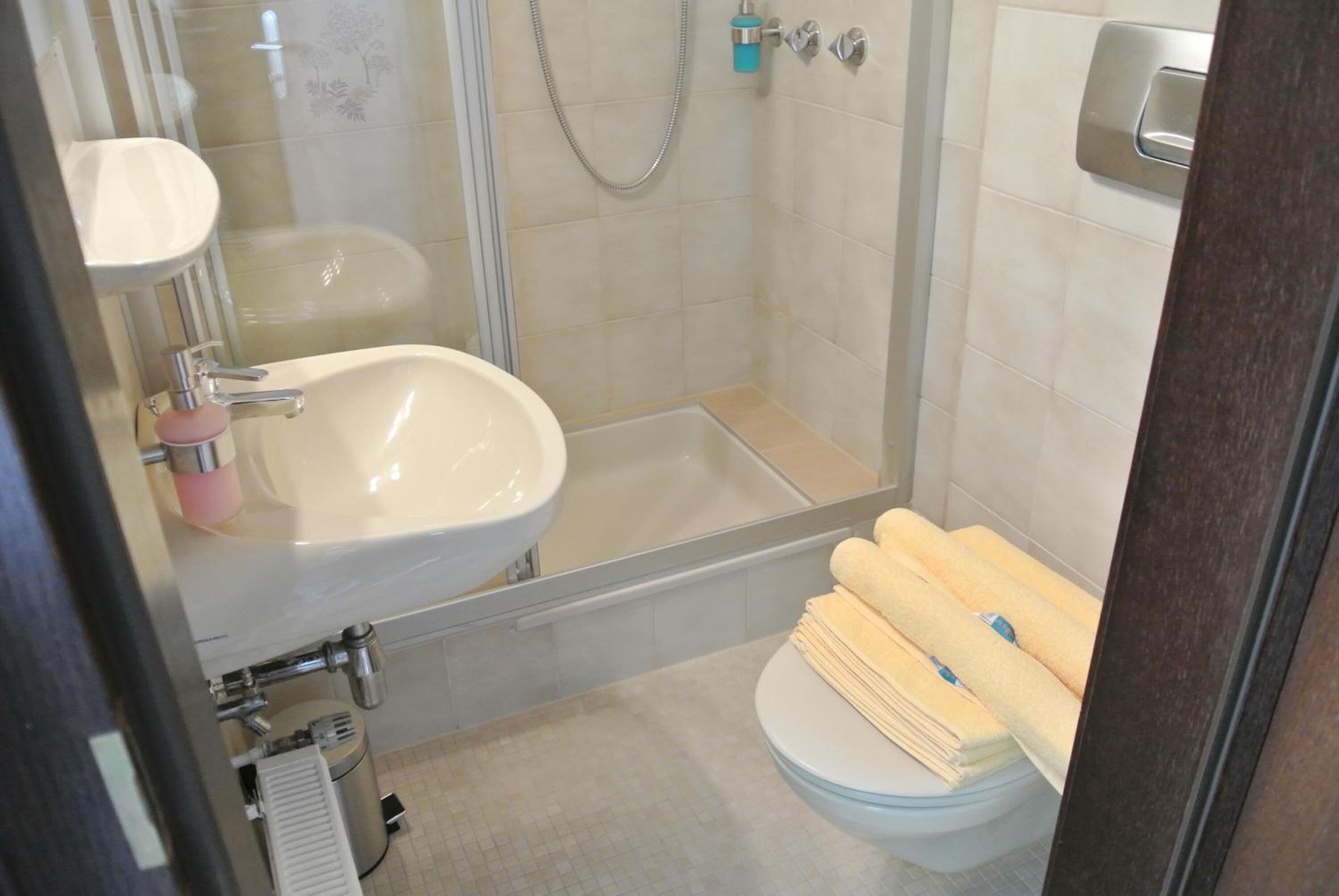 A bathroom with a sink, toilet, and shower.