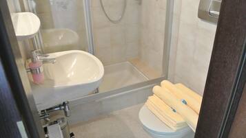 A bathroom with a sink, toilet, and shower.