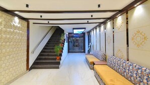 Un pasillo con una escalera, un banco y paneles decorativos en la pared.