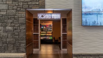 A Tonic Kitchen & Bar entrance with a stone wall backdrop and a modern interior.