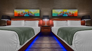Camera d'albergo con due letti, una testiera in legno e un percorso illuminato di blu.