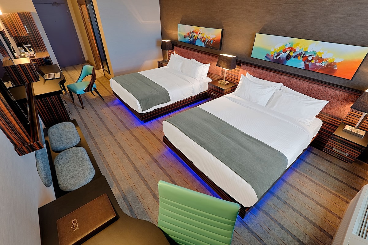 Una habitación de hotel con dos camas, un escritorio y una silla.