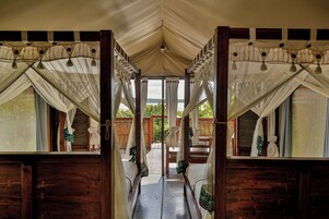 Un pasillo que conduce a una habitación con cama a dosel, paredes de madera y vistas al exterior.