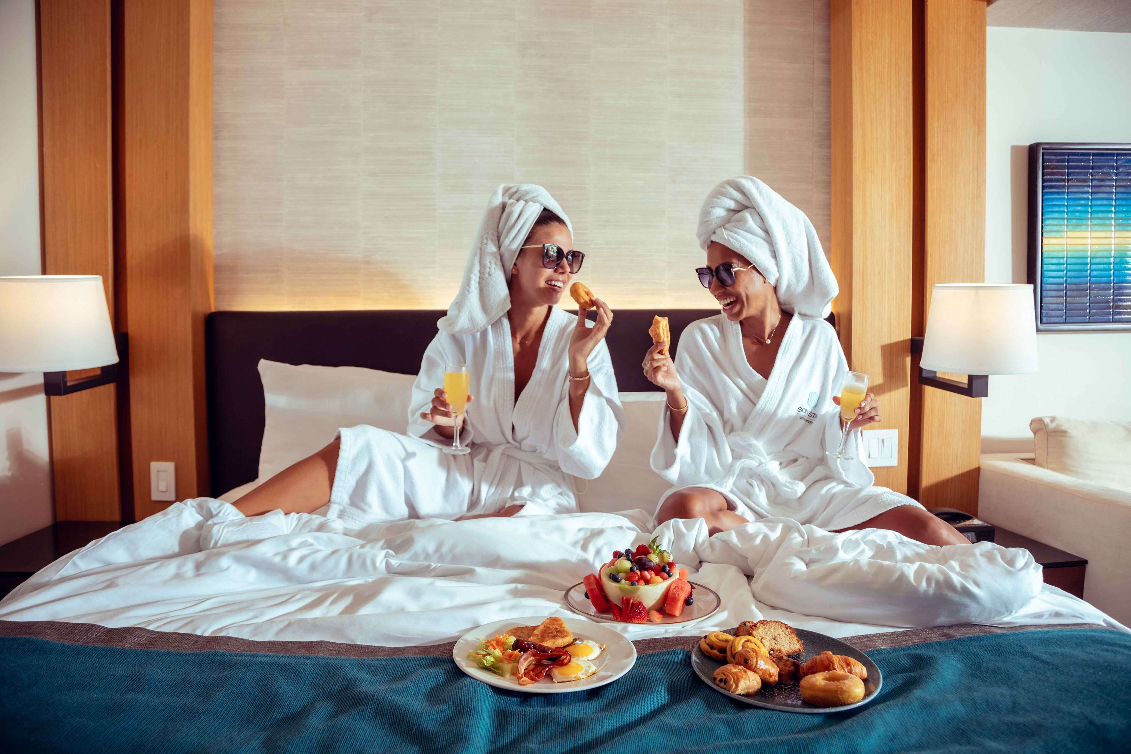 Une chambre d’hôtel avec un lit, un coin pour prendre le petit-déjeuner et un tableau accroché au mur.