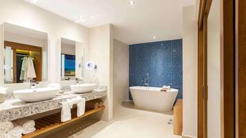 A modern bathroom with two sinks, a freestanding bathtub, and a blue-tiled wall.