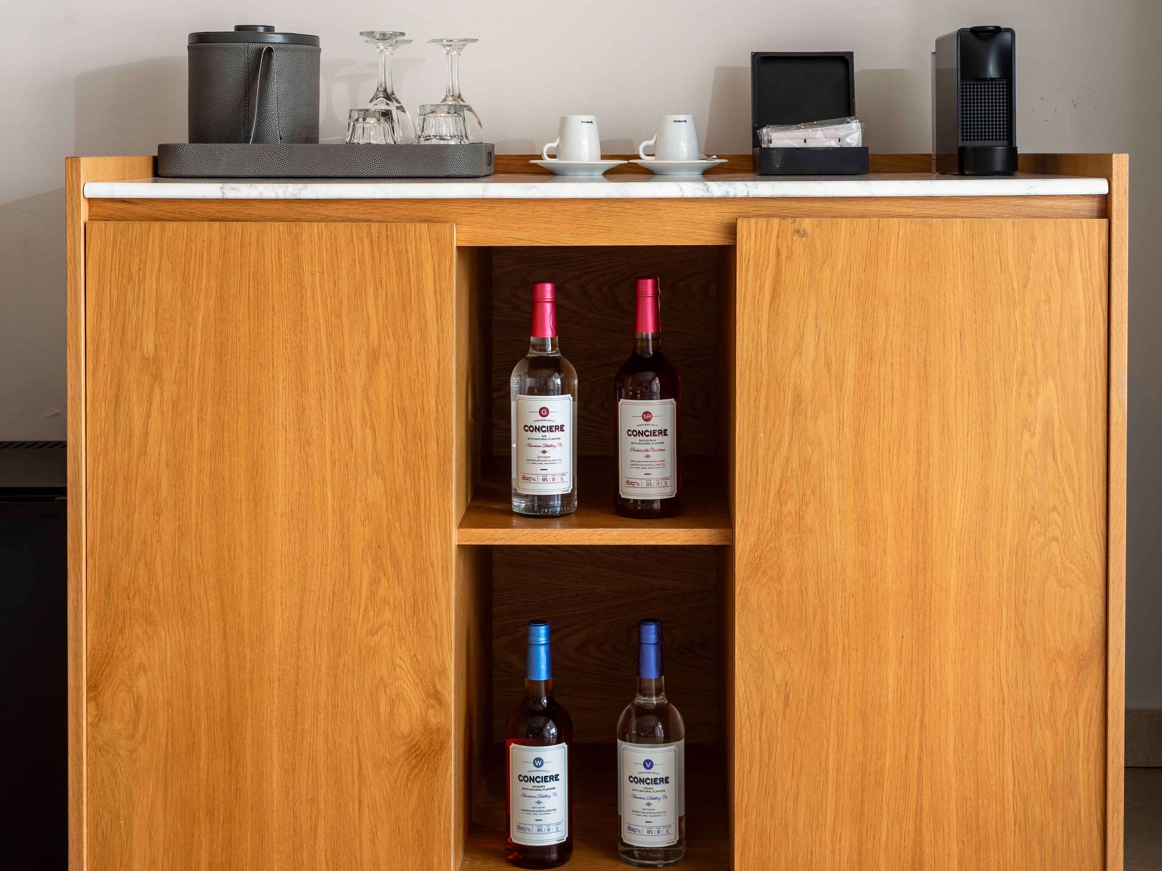 Un gabinete de madera con tres estantes, cada uno con una botella de vino Concieri.