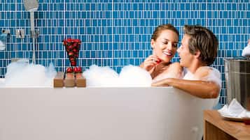 Una bañera llena de burbujas y una cesta de fresas.