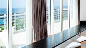 A modern room with a long black countertop, large windows with a view of the ocean, and a curtain. - Sonesta Ocean Point All Inclusive, Adults Only Resort (Lowlands)