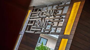 A wooden gate with the words "OCEAN POINT" engraved on it.