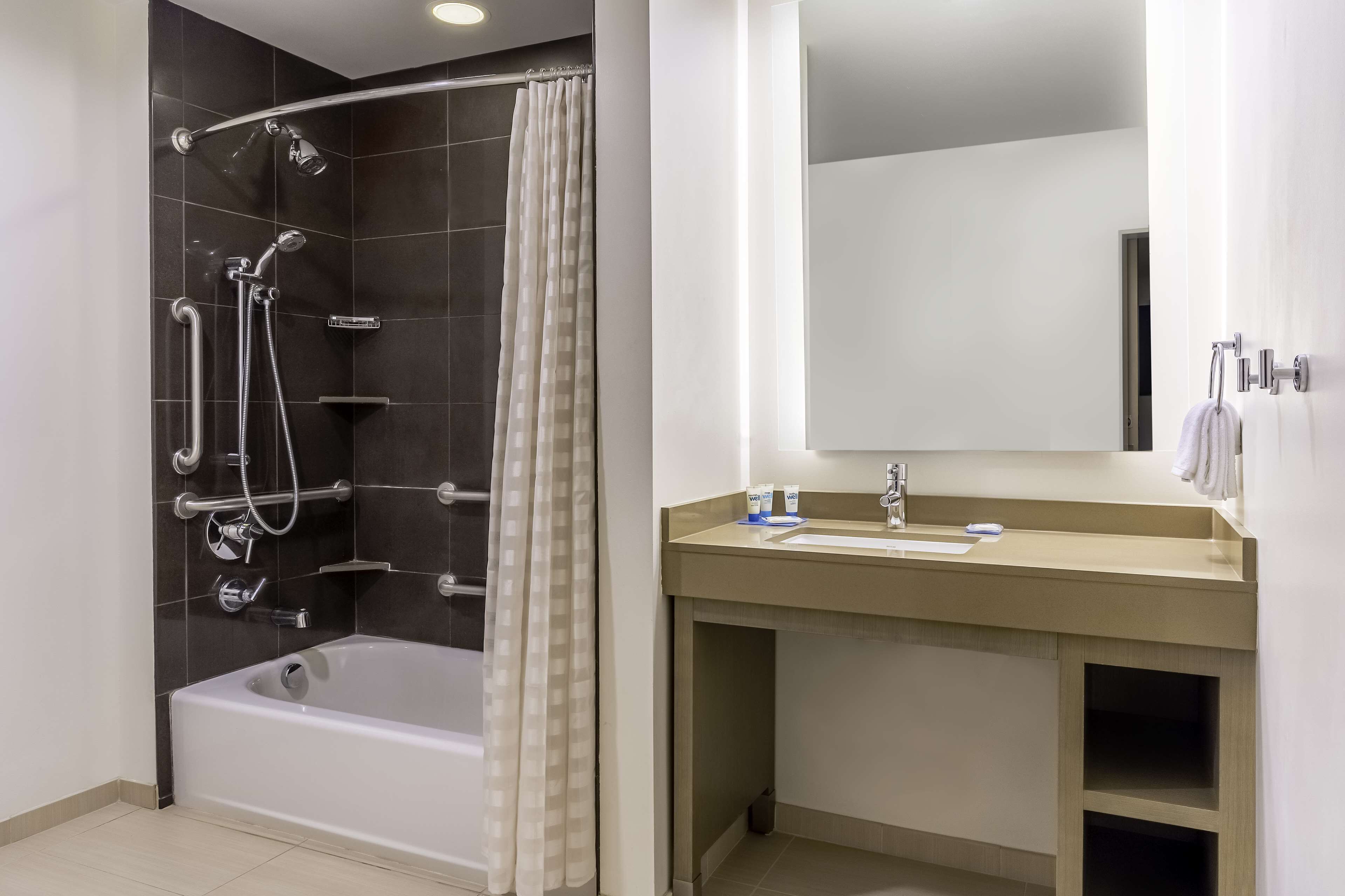 A modern bathroom with a bathtub, shower, and vanity.