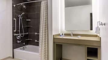A modern bathroom with a bathtub, shower, and vanity.