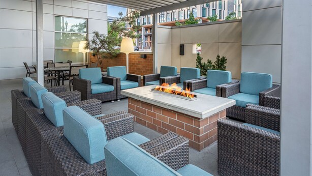 An outdoor seating area with wicker furniture and a central fire feature. - Hyatt House Salt Lake City Downtown (Salt Lake City)
