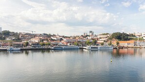 Un río con barcos, un paisaje urbano con edificios y un cielo despejado.