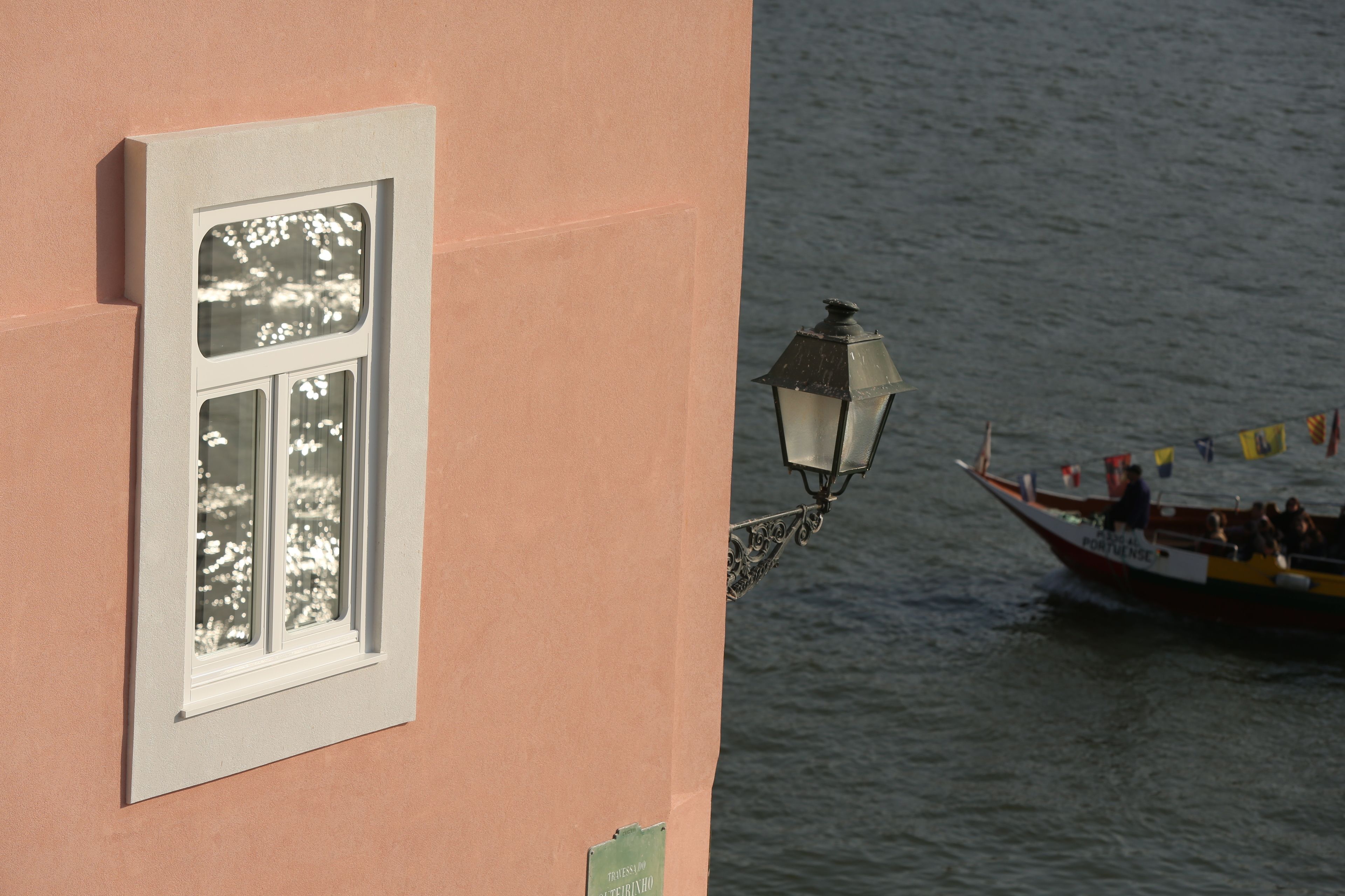 A building with a window and a wall-mounted lamp.