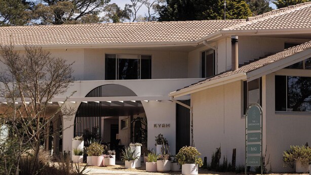 A modern building with a tiled roof, an arched entrance, and potted plants. - Kyah Hotel (Blackheath)