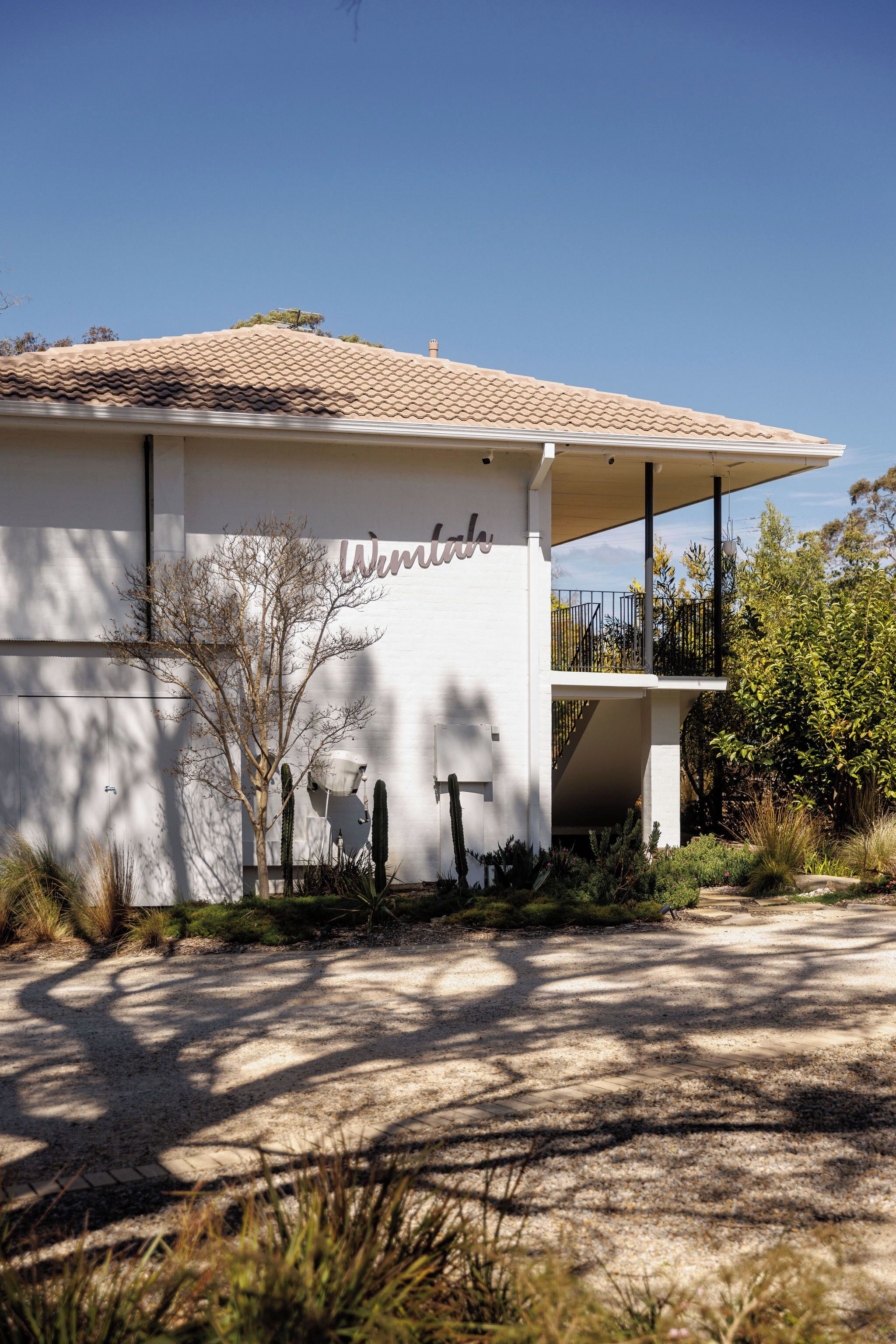 A modern building with a white facade and a tiled roof.