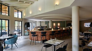 A spacious restaurant with a long bar, high ceilings, and large windows. - Kyah Hotel (Blackheath)