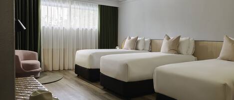 Een hotelkamer met twee bedden, een stoel, een hoed en een lamp.