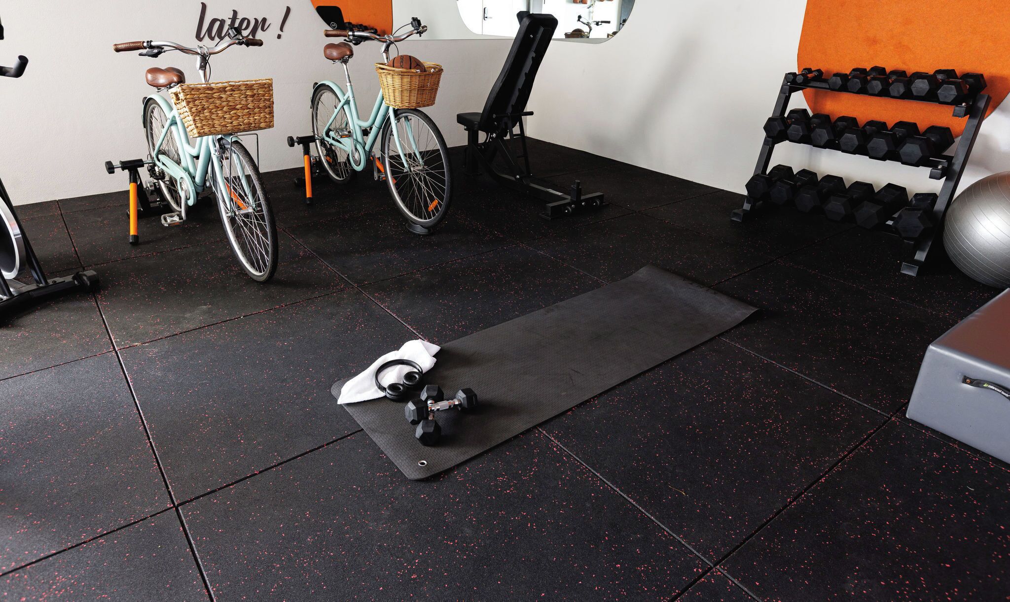 A gym with exercise equipment, a stationary bike, and a yoga mat.