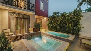 Un espace piscine extérieur moderne, doté d’un coin salon et d’un bâtiment avec balcon.