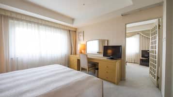 Una habitación de hotel con una cama, un escritorio con computadora, televisor y espejo.