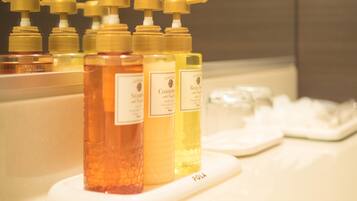 A row of toiletries on a white tray in a bathroom.