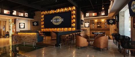 A bar area with a neon sign, seating, and a pool.