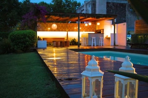 Una piscina al aire libre, sillones reclinables de piscina